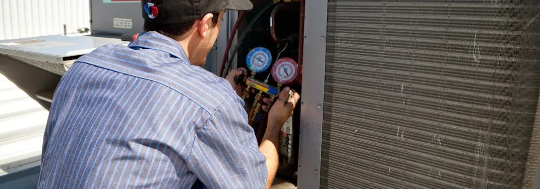 HVAC technician servicing a condenser unit in Waco