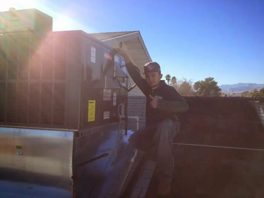 HVAC technician performing Air Duct Cleaning on a rooftop unit in Waco